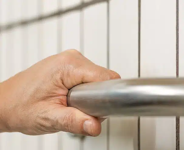 elderly person with a hand on a grab bar